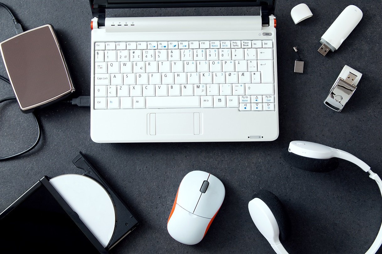 Laptop mit USB-Stick, Kopfhörern, Maus, externer Festplatte und CD